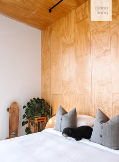 Tinted radiata pine ceilings, walls, and flooring partly envelop the guest bedroom for a cozy feel.