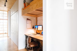 A hallway with floor-to-ceiling custom cabinetry separates the living areas from the two bedrooms. The hallway also contains a small workstation.