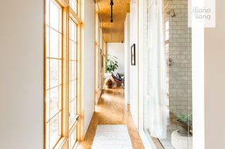 Long light-filled hallways on either side of the house connect the living area to separate entrances to the two bedrooms.