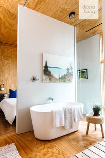 A Signature Hardware soaking tub overlooks views of the wetlands in the master bath.