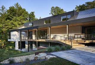 Topped with a custom-made steel roof, the home is wrapped in glass and painted brick.