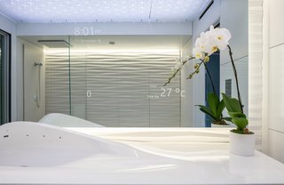 The smart mirror allows residents to control the bathroom's features with a touch—and it can even pull up real-time weather and traffic data.