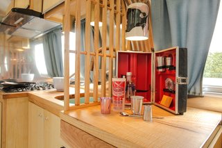 A securable ceramic pendant light by Brooklyn–based potter Helen Levi hangs above the ash countertop. Robin purchased a bar kit with 1960s World's Fair glasses as a nice surprise for the client.