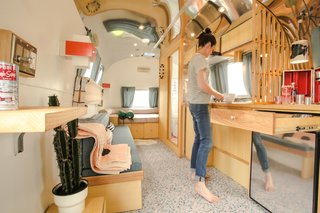 BORIEN Studio designed and built all of the woodwork from Canadian Ash. "The trees are being decimated by beetles, so we wanted to preserve this beautiful wood within the bus," says Robin, who is pictured at the kitchen.
