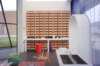 A wall in "Tomorrow" comprises consecutively numbered bright orange Ceramic Blocks that double as storage.
