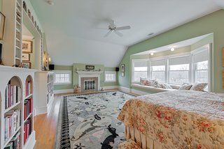 The spacious master bedroom includes a window seat, extensive build-ins, walk-in closets, and a fireplace.