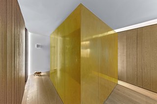 The bedroom is enclosed in a cube clad in unlacquered brass. The floors are wide-plank European white oak.