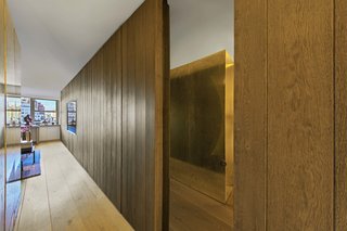 A smoke-gray mirrored door reflects the bedroom cube and leads to the bathroom near the entrance.