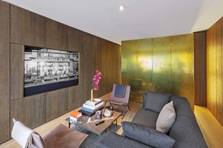 The doors to the bedroom can be closed when guests visit. Sunlight from the west-facing windows bounces off the brass cube and bathes the living area in golden light.