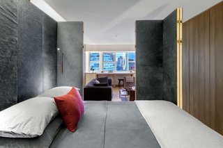 The walls of the brass bedroom cube fold back to reveal the living room on one side and the entry hall on the other.
