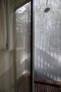 A perforated metal screen provides privacy for the outdoor shower, where guests can experience "bathing in the forest."