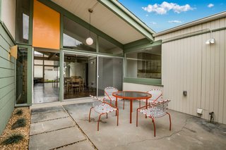 The recently renovated home features period-appropriate lighting fixtures that help tie the building to its midcentury roots. The wall sconce seen to the left is an original fixture.