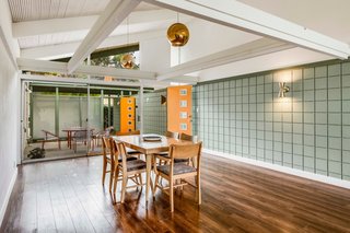 The wood-slatted drop ceiling was removed in the dining area and the ceilings and beams were painted white to create a greater sense of spaciousness.