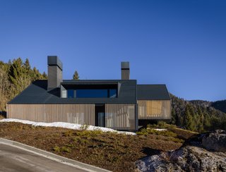 The Z House's structure consists entirely of concrete. Wood screens wrap around the sides, and Prefa materials top the roof.