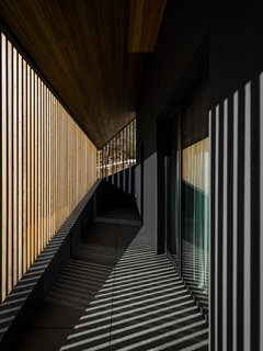 The vertical larch elements are not uniformly placed around the house, note the architects. "The wooden blades have different orientations. They are sometimes rotated—the spacing is not constant. They open up to let you see, and they hide and hide. They condition the internal relationship between inside and outside, and so the light vibrates and changes constantly on the outer skin of the house. It is a subtle and iridescent vibration, with the light of the Alps."