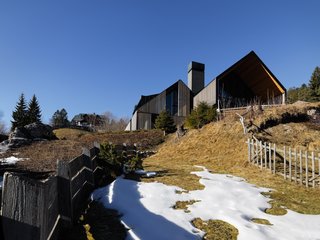 "The approach path is one of the key points of the project. The arrival is a precise and inevitable sequence: the road climbs steeply, the house shows itself from afar in the middle of other buildings, then hides, and then reappears in a scenic perspective from the bottom where you can feel the whole size of the building," says GEZA.