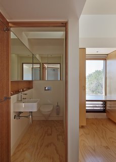 A long line of mirrors makes the compact bathroom feel more spacious.