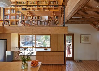 The floating stainless steel countertop is supported by a steel rod to allow the cabinet underneath to roll in and out.