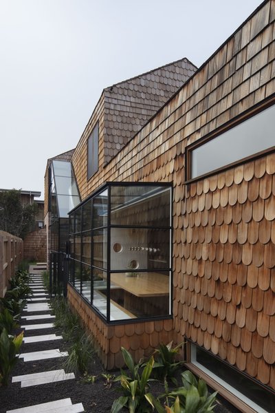 Taking cues from historic European architecture, the facade is clad in overlapping cedar shingles that will develop a silvery patina over time.