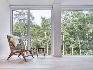 Large windows in the upstairs bedrooms create the illusion of being immersed in the treetops. The custom furniture is by Santiago Torres.