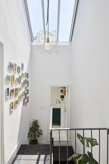 A new skylight floods the upper floor with natural light. The lighting fixture is from Rockett St George.