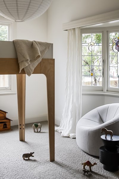 Inside one of the kids’ bedrooms at the front of the house is an Oeuf Perch lofted double bed, a Pumpkin armchair by Ligne Roset, and a Grain Cut side table in black from Domo.