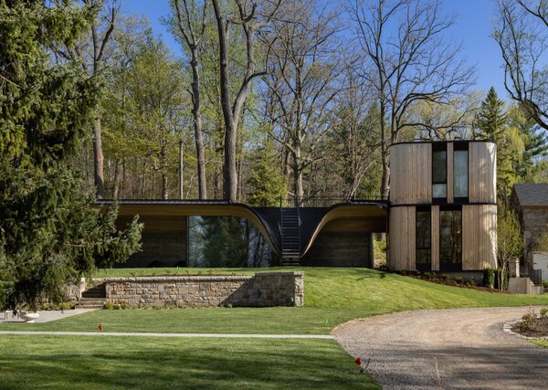 The 338-square-foot Fold House combines a pool pavilion embedded into the hillside with a two-story guesthouse.