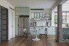 Modern home with Dining Room, Table, Storage, Medium Hardwood Floor, Shelves, Ceiling Lighting, and Chair. An apartment on the ground floor of a terraced house was transformed from a small and gloomy dwelling to a bright and spacious studio apartment. Photo 6 of C Studio Apartment