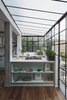 Modern home with Kitchen, Medium Hardwood Floor, Colorful Cabinet, Wood Cabinet, Engineered Quartz Counter, Marble Backsplashe, Cooktops, and Undermount Sink. A greenhouse-like facade was created, connecting the verdant outdoors with the kitchen and living area. Photo 5 of C Studio Apartment