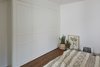 Modern home with Ceiling Lighting, Medium Hardwood Floor, and Storage. In the bedroom, storage space is concealed behind white joinery cabinets. Allowing a roomy yet snug atmosphere. Photo 14 of C Studio Apartment