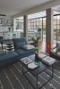 Modern home with Living Room, Chair, Medium Hardwood Floor, Sofa, Ceiling Lighting, and Coffee Tables. Two concrete columns were exposed, to contradict and complement the bright and clean appearance of the common space. Photo 7 of C Studio Apartment