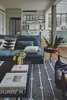 Modern home with Living Room, Sofa, Coffee Tables, Chair, Ceiling Lighting, and Medium Hardwood Floor. The living room and kitchen area are flooded with natural light, that enters from the greenhouse-like facade. Photo 8 of C Studio Apartment