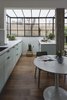 Modern home with Kitchen, Colorful Cabinet, Wood Cabinet, Marble Backsplashe, Engineered Quartz Counter, Medium Hardwood Floor, and Undermount Sink. The kitchen area, watching over the front yard through the framework windows. The color scheme was designed to allow a mellow and delicate feel, a sort of an extension of the peaceful outdoors. Photo 3 of C Studio Apartment