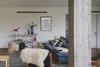 Modern home with Living Room, Chair, Ceiling Lighting, Console Tables, Ottomans, Sofa, and Medium Hardwood Floor. An eclectic collection of furniture and objects give the space a young and fresh feel, along with the clean architectural lines and spaces. Photo 9 of C Studio Apartment