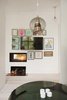 Modern home with Living Room, Coffee Tables, Pendant Lighting, Wood Burning Fireplace, and Light Hardwood Floor. The flat screen TV blends in with several pieces of framed artwork and a wood burning fireplace. Photo 14 of Colorful & Eclectic Danish Home