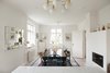 Modern home with Dining Room, Light Hardwood Floor, Table, Ceiling Lighting, Standard Layout Fireplace, and Wood Burning Fireplace. Dining area with white walls, black table, and royal blue accent rug and wood burning fireplace Photo 2 of Colorful & Eclectic Danish Home