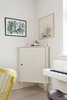 Modern home with Dining Room, Storage, and Light Hardwood Floor. Corner vignette of dining room with white antique cabinet and modern art Photo 3 of Colorful & Eclectic Danish Home