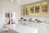 Modern home with Kitchen, Marble Counter, Dishwasher, Range, Colorful Cabinet, Ceiling Lighting, and Drop In Sink. Sleek white kitchen is given a pop of color and old world charm with yellow stained glass cabinets. Luxurious marble countertop and island are also featured. Photo 8 of Colorful & Eclectic Danish Home