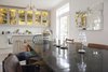 Modern home with Dining Room, Table, Ceiling Lighting, Stools, Lamps, Accent Lighting, and Light Hardwood Floor. Dining area with black table leading into a view of open kitchen. Yellow stained glass cabinets add color to the room, and candles and small accent lamps sit upon the dining table. Photo 4 of Colorful & Eclectic Danish Home