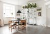 Modern home with Dining Room, Table, Lamps, Floor Lighting, Pendant Lighting, Shelves, Storage, and Medium Hardwood Floor. Contemporary Scandinavian dining room with round black table and metal open shelving Photo 2 of Minimalist Nordic Flat