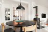 Modern home with Dining Room, Chair, Table, Pendant Lighting, Ceiling Lighting, Medium Hardwood Floor, and Wood Burning Fireplace. Open dining room featuring black table, wood chairs, and black metal pendant light Photo 5 of Minimalist Nordic Flat
