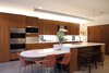 Modern home with Kitchen, Engineered Quartz Counter, Wood Cabinet, Concrete Floor, Recessed Lighting, Pendant Lighting, Refrigerator, Glass Tile Backsplashe, Microwave, Wall Oven, Range Hood, Cooktops, and Undermount Sink. Kitchen Photo 5 of Before House