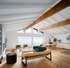Modern home with Living Room, Chair, Ceiling Lighting, Sofa, Coffee Tables, and Medium Hardwood Floor. View from Living Room, looking towards the water. The kitchen, with plywood cabinets and terrazzo counter, is visible to the right. Photo 4 of Waterfront House