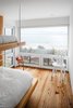 Modern home with Bedroom, Chair, Bed, and Medium Hardwood Floor. View of new bunk bed room. This room used to be a corner of the old Master Bedroom. We We reconfigured the space into a small and cozy corner bedroom, shaped by a new corner window. Photo 7 of Waterfront House