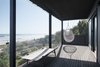 Modern home with Exterior, Beach House Building Type, and House Building Type. View of lower deck, looking east. We used solid wood rails on the sides and glass on the front, in order to direct the views towards the water. Photo 8 of Waterfront House