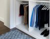 Modern home with Storage Room and Closet Storage Type. This unit was specifically designed with a variety of open shelves, hanging sections, and shoe storage. Hanging sections provide enough elevation to conveniently organize items based on size. From blazers and blouses to maxi skirts and evening gowns, all of your clothing is easily accessible. By using the same color hangers, your space will appear even more collected and composed. You can also arrange your clothing so that the colors compliment each other and appear as the favorable options they really are.
For the shoe enthusiast, we included numerous sets of shoe shelves and cubbies that attractively organize and showcase your finest footwear. This type of system allows you to identify and grab your favorite pair as you mix and match the perfect ensemble. Photo 4 of Crisp White Walk-In Closet