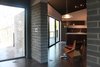 Modern home with Living Room, Accent Lighting, Chair, Ceiling Lighting, and Dark Hardwood Floor. A 17-foot expanse of glass with walls and floors that reach through to the outside connects the inside with nature. Photo 4 of The Woung House