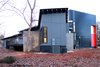 Modern home with Exterior, Flat RoofLine, Brick Siding Material, Metal Siding Material, Concrete Siding Material, Metal Roof Material, Shed RoofLine, and House Building Type. Masonry walls slice through the home and structure the spaces. Photo 5 of The Woung House