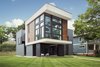 Modern home with Exterior, Wood Siding Material, Concrete Siding Material, Flat RoofLine, House Building Type, and Glass Siding Material. The "C" shaped living room boasts with a 18' tall ceiling, cantilevering over a street corner. Photo 2 of Gillingham Strauss Residence