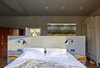Modern home with Bedroom, Medium Hardwood Floor, Dresser, Wardrobe, Ceiling Lighting, Night Stands, Wall Lighting, and Bed. Creueta House-Master bedroom. Photo 10 of Creueta House
